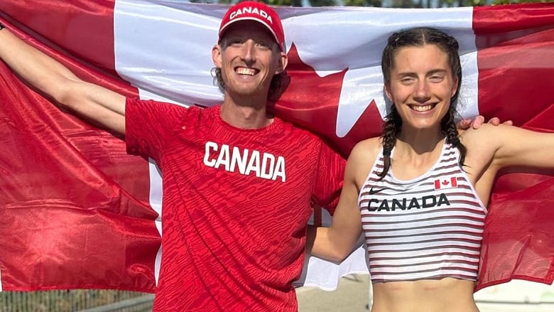 A male race walker and his female teammate extend their arms to hold a Canadian flag behind their back after setting a national record and qualifying for the Paris Olympics at  the World Athletics Race Walking Team Championships in Antalya, Turkey.