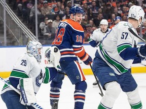 Vancouver Canucks' goalie Casey DeSmith (29) makes the save as Edmonton Oilers' Zach Hyman (18) looks for the rebound during second period NHL action in Edmonton, Saturday, April 13, 2024.