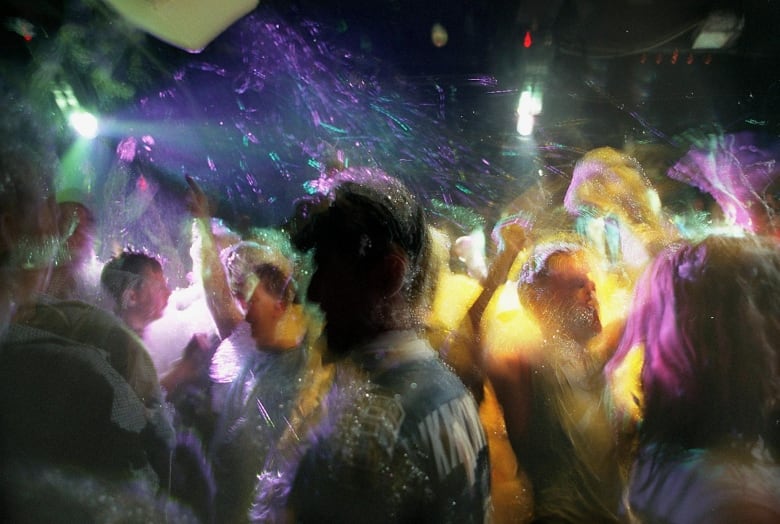 Young people dance at a foam party