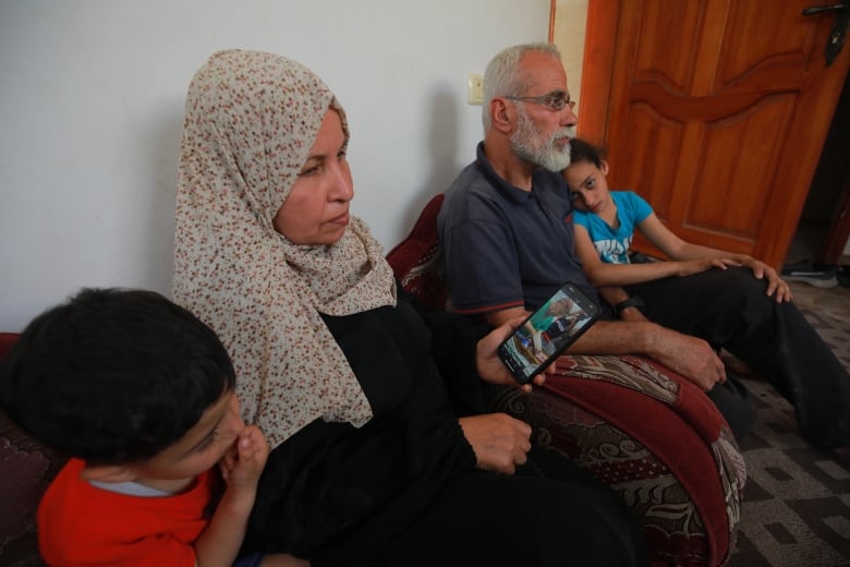 Family members sit on the floor as they await news on a newborn baby in hospital. 