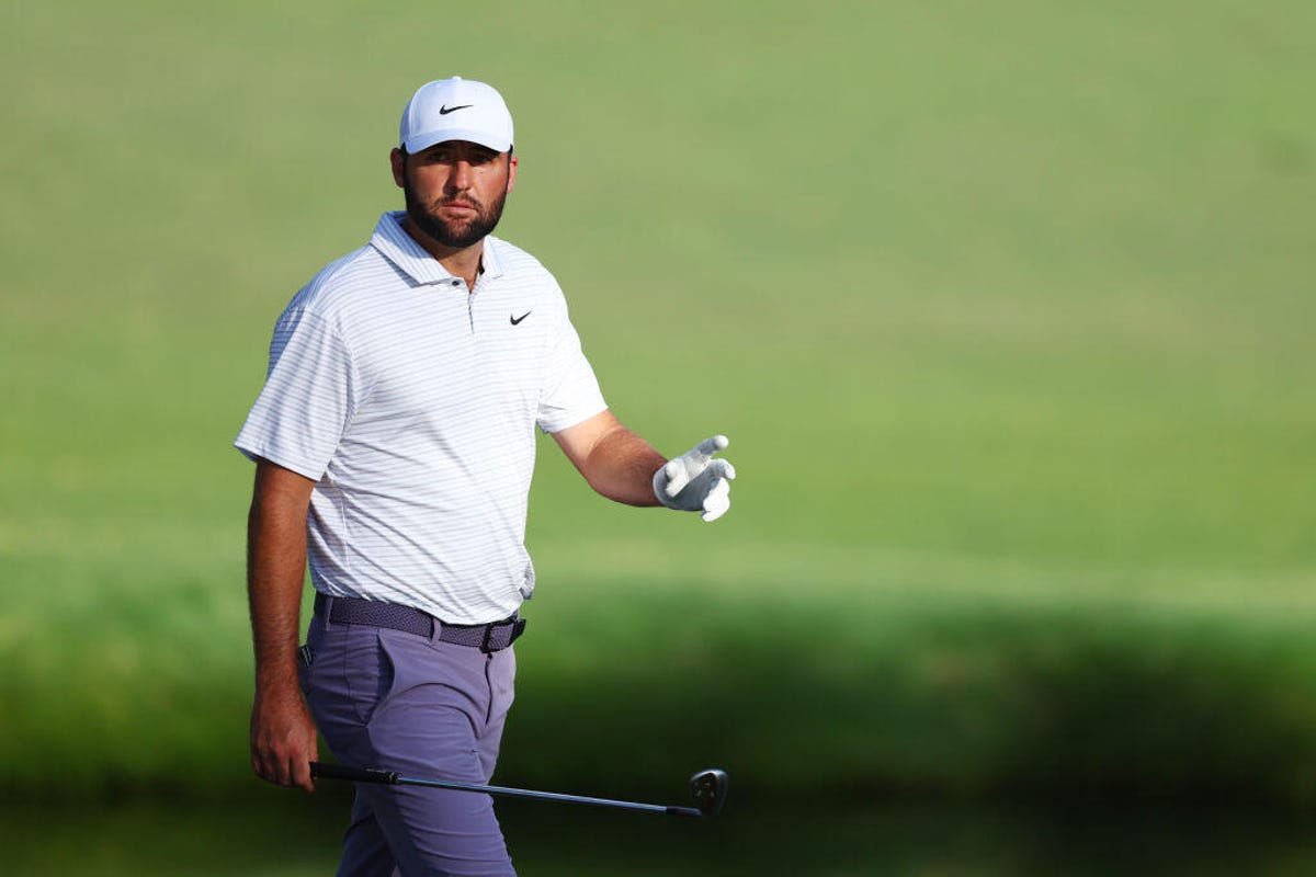 Scottie Scheffler of the United States acknowledges the crowd walking to the 15th green during the third round of the 2024 Masters Tournament at Augusta National Golf Club