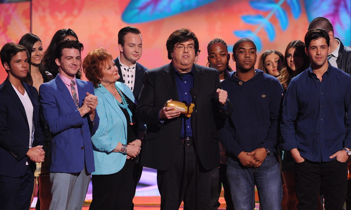 crowd of people stand on stage at awards ceremony