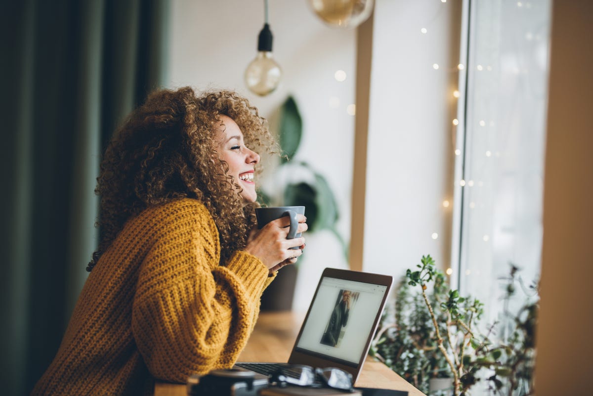 Woman holding a cup of coffee while smiling