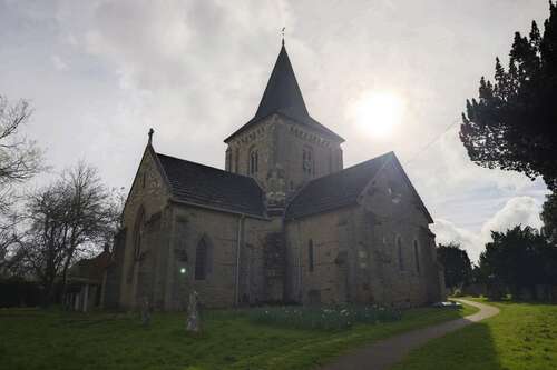 A photo of an orb floating over a gravestone in a churchyard.