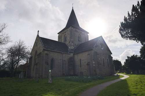 A photo of an orb floating over a gravestone in a churchyard.