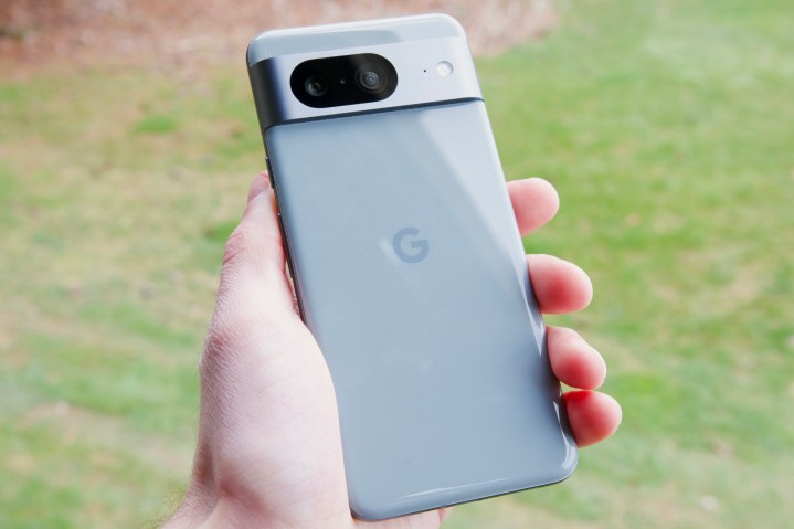 Someone holding the Google Pixel 8 outside, showing the back of the phone.