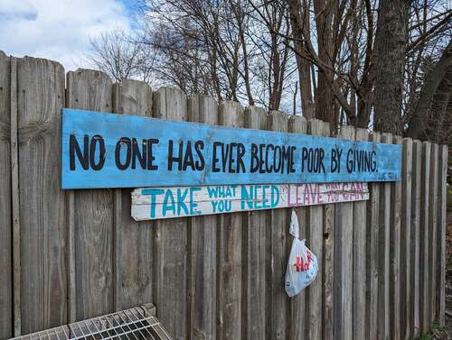 A photo of a blue sign on a fence, taken with the Google Pixel 8.