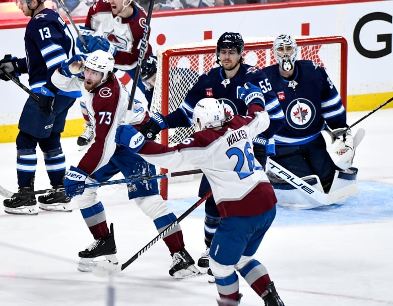 A hockey player holds his right hand to his ear after scoring.