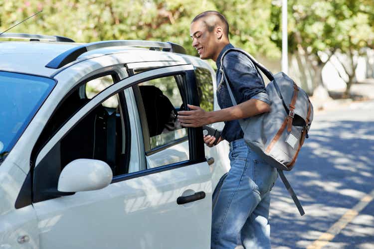 Male student entering car on roadside