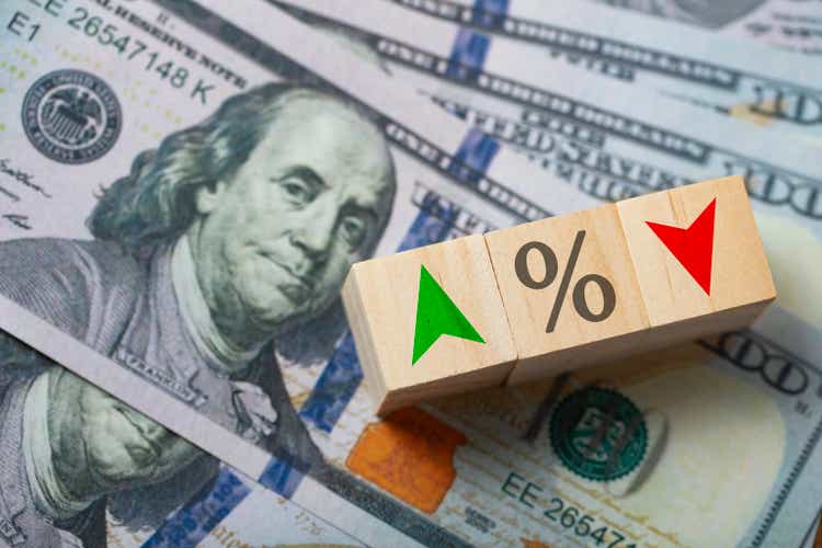 The central banking system of the United States and changing interest rates. Percentage symbol and arrow symbol on the wooden cube.