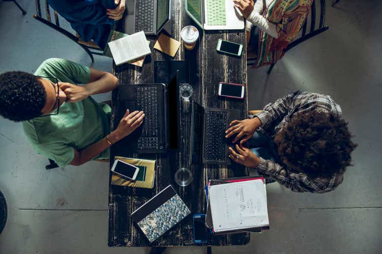 Directly above shot of male and female friends studying at home