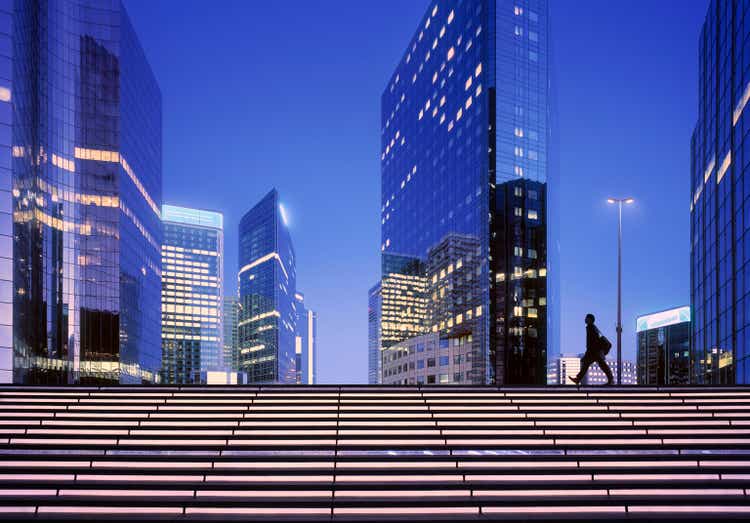 Businessman arriving at modern business district at dawn