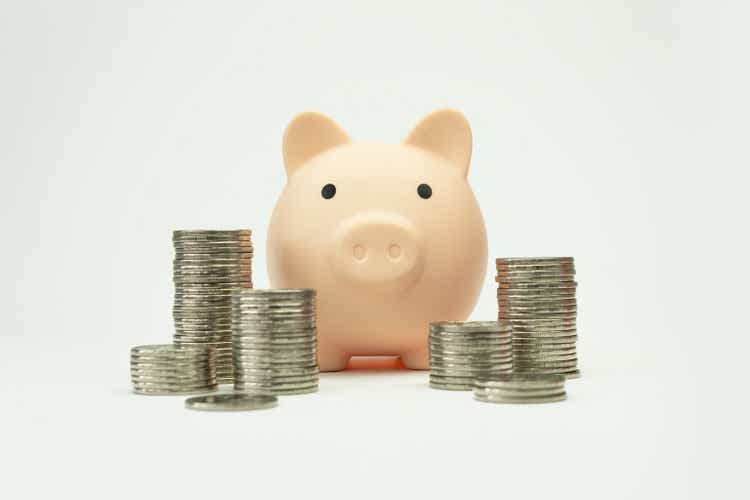 Silver coins stack and pink piggy bank on white background with growth, Coins arranged as graph. Concept of money saving and business finance.