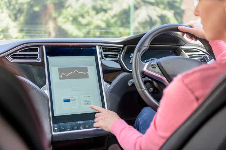 Woman using graphical display in electric car