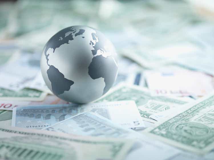 Metal globe resting on paper currency