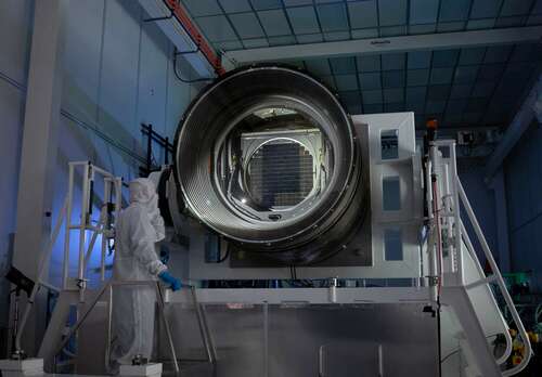 Travis Lange, a deputy project manager for the LSST Camera, inspects the car-sized instrument.