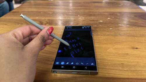 Samsung Galaxy S24 Ultra on a table with S Pen in a woman's hand