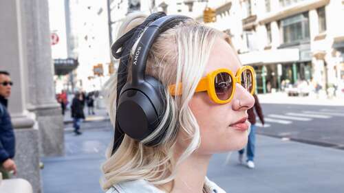 woman wearing over-ear headphones outside on NYC street