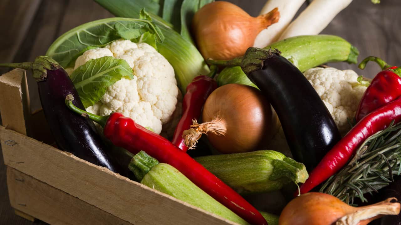 Different kind of local vegitables on the wooden rustic table.