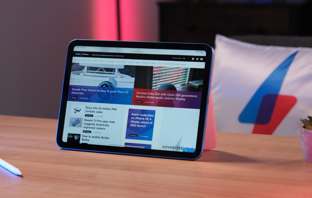 Apple iPad on desk displaying tech news website.