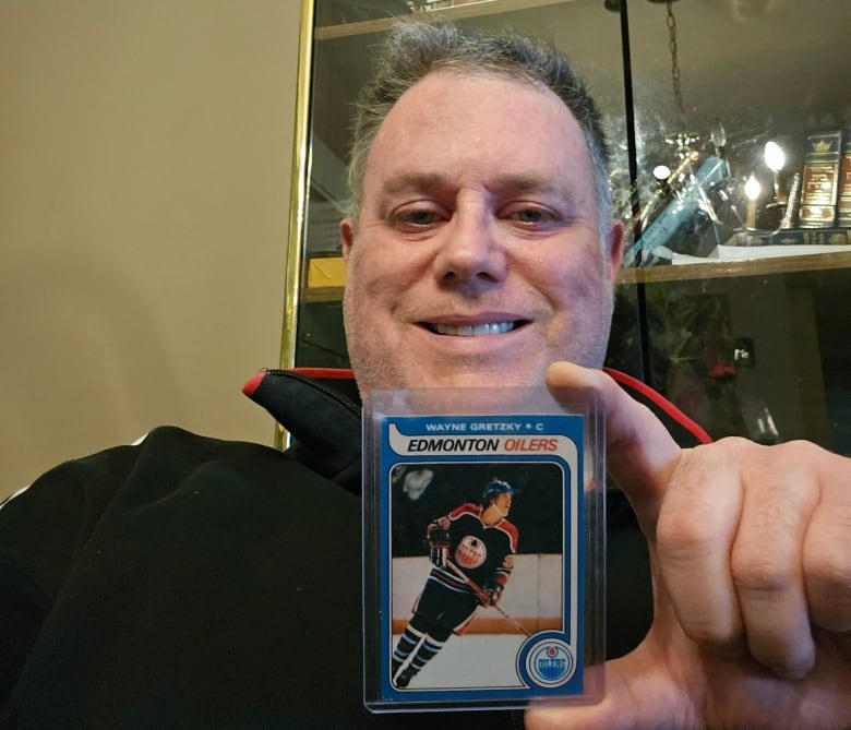Jack Arshawsky is holding a wayne gretzky hockey card 