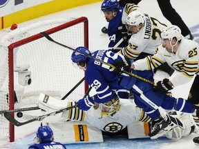 Boston Bruins goaltender Jeremy Swayman (1) makes a save on Toronto Maple Leafs' Tyler Bertuzzi (59) as Bruins' Hampus Lindholm (27) and Brandon Carlo (25) defend and Maple Leafs' Auston Matthews (34) looks on during third period action in Game 3 of an NHL hockey Stanley Cup first-round playoff series in Toronto on Wednesday, April 24, 2024.