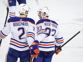 Edmonton Oilers defenceman Evan Bouchard (2) celebrates his goal with teammate forward Ryan Nugent-Hopkins (93) during third period NHL hockey action against the Calgary Flames in Calgary, Alta., Saturday, April 6, 2024.