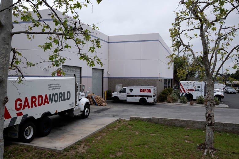 Trucks are shown outside closed garage doors of a warehouse-type facility.