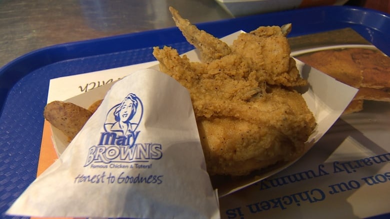 A serving of chicken strips on a blue food court tray.