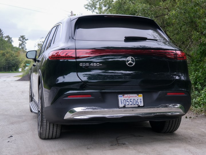 Rear of the 2024 Mercedes-Benz EQS 450+ on front of trees