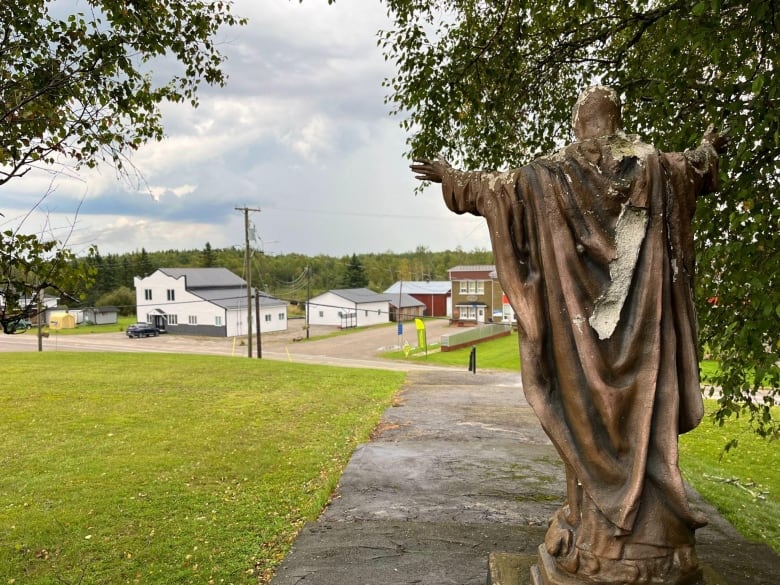 A statue overlooks a small town. 