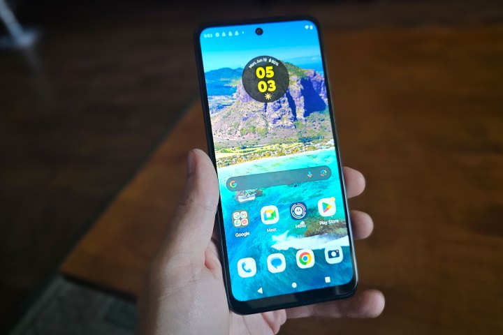 Someone holding the Moto G 5G (2023) with the display turned on.