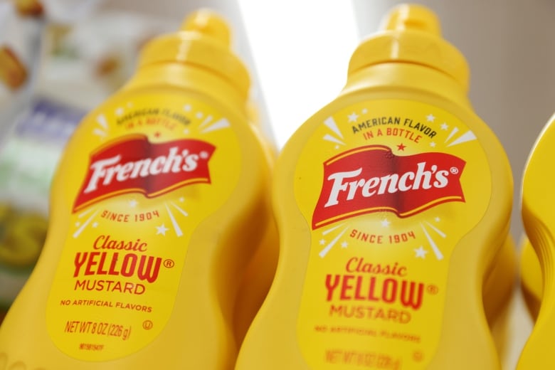 Two bottles of French's yellow mustard on a  store shelf