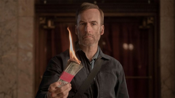 Bob Odenkirk holds something that is burning in Nobody.