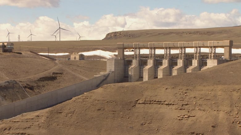 A dam is pictured along a hillside.