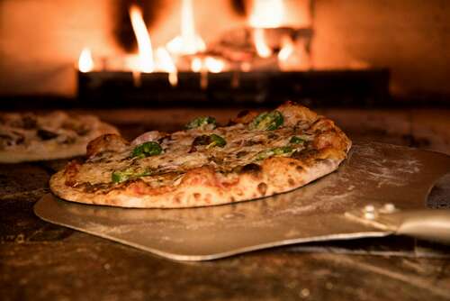 baked pizza on pizza peel in oven