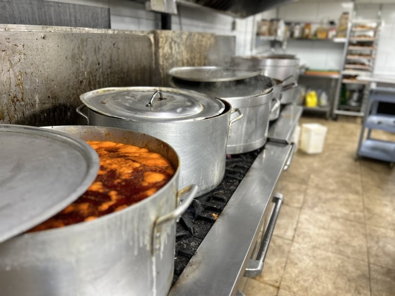 Industrially sized pots filled with reddish liquid.