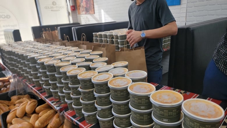 Piles of small takeout soup containers.