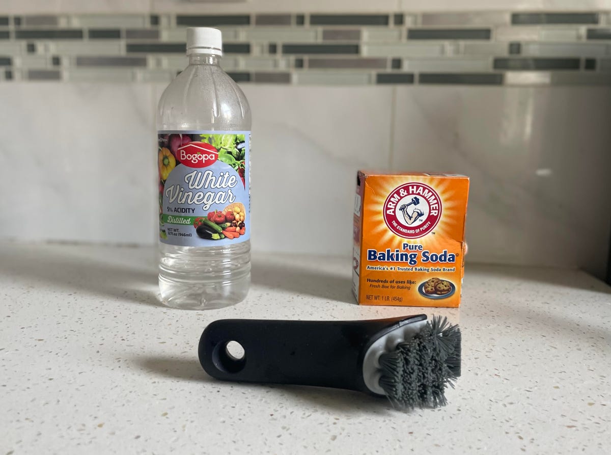 baking soda white vinegar and scrub brush on counter