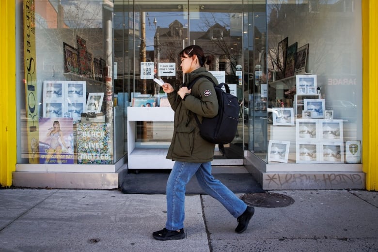 A woman walks past a record store.