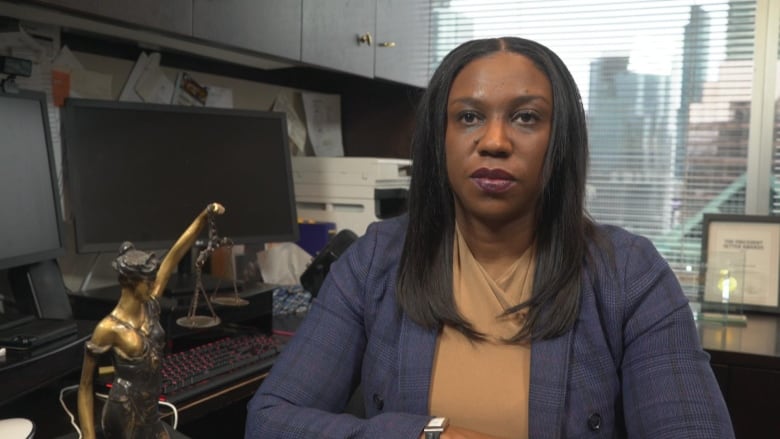 A woman sits at a desk inside her law office.