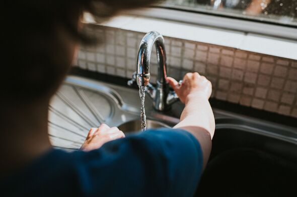 Person turning tap on