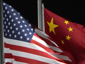 FILE - The American and Chinese flags wave at Genting Snow Park ahead of the 2022 Winter Olympics, Feb. 2, 2022, in Zhangjiakou, China. For the first time in nearly two years, U.S. and Chinese defense officials met this week to discuss unsafe and aggressive ship and aircraft incidents between the two militaries in the Pacific region, restarting a dialogue that Beijing abruptly ended in a dispute involving Taiwan. The meeting, which was Tuesday through Thursday in Hawaii, comes as Washington and Beijing work to expand communications between the two world powers and ease escalating tensions.