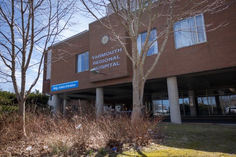 A red brick building is shown with trees in the foreground and a sign on the front that says Yarmouth Regional Hospital.