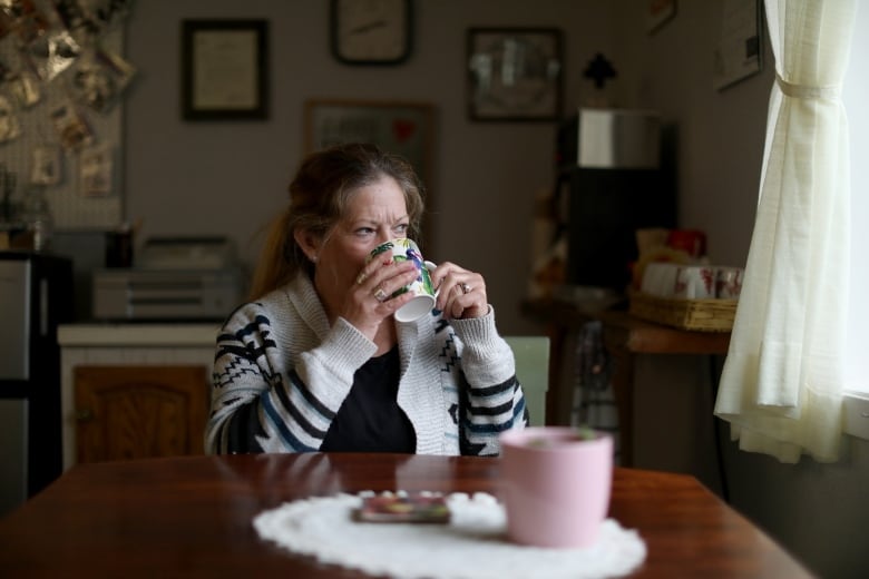 A woman sips coffee.