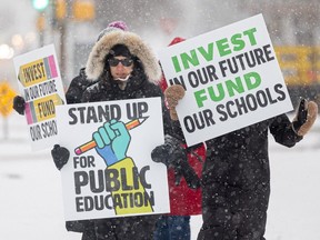 Teachers holds signs