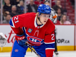 Canadiens' Kaiden Guhle is seen in his home red jersey crouching in position for a faceoff.