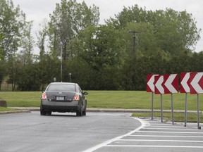 A car on a road that ends in a grassy area