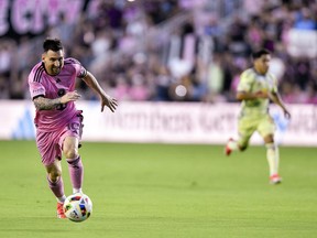 Lionel Messi kicks a ball while running on the pitch