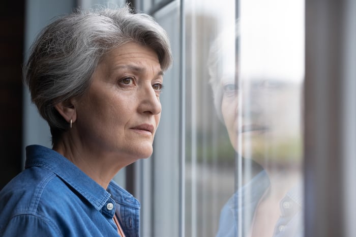 Stressed person looking out of a window.